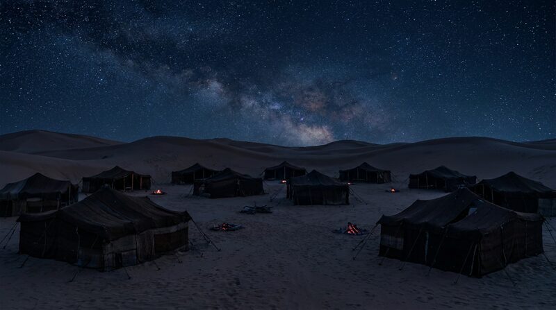 Campamento de tiendas bajo el cielo nocturno del desierto